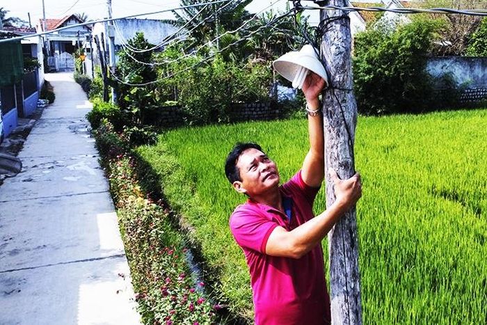  Ông Nguyễn Bình đang sửa đường điện thắp sáng đường quê. 