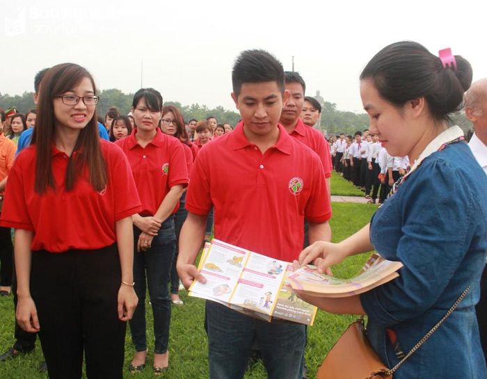 Cán bộ Trung tâm Kiểm soát bệnh tật phát tờ rơi về phòng chống bệnh dại. Ảnh: Thanh Hoa