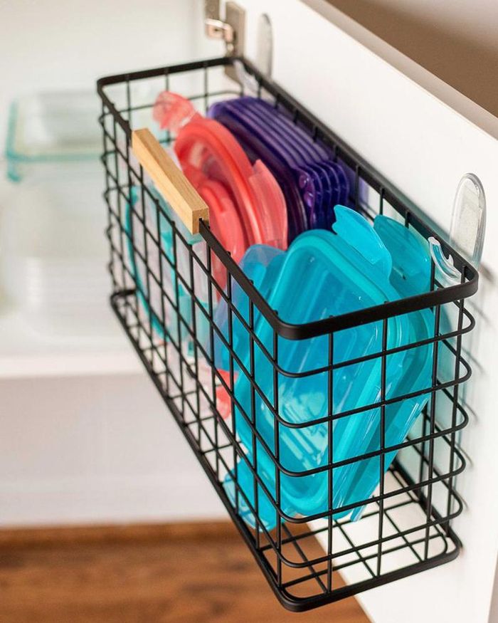 Một chiếc giỏ treo sau cánh tủ cung cấp cho bạn nơi cất trữ nắp hộp đựng thực phẩm tiện lợi.