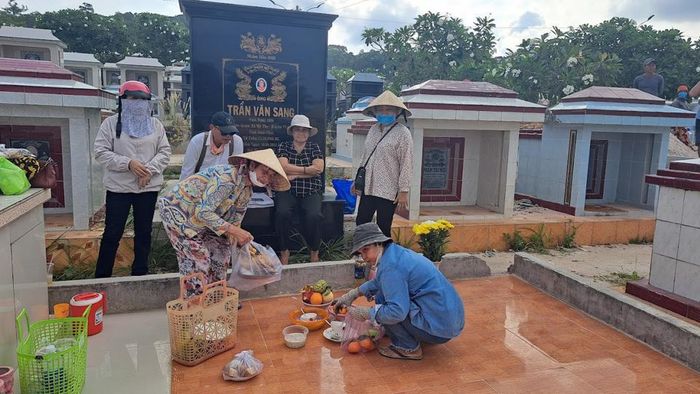 Người dân Phú Quốc bày hoa quả, giấy tiền, gà để cúng người thân. Ảnh Hữu Tuấn