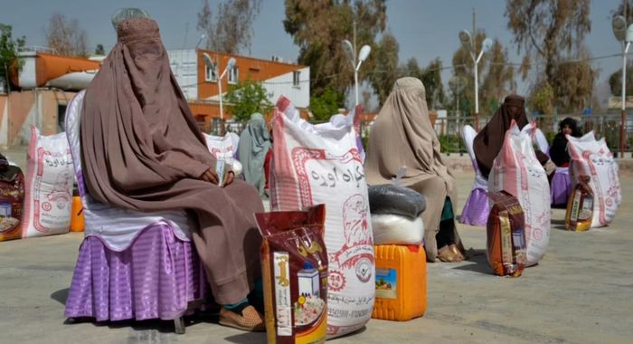 Phụ nữ Afghanistan ngồi sau khi nhận viện trợ lương thực do một tổ chức từ thiện phân phát trong tháng ăn chay Ramadan của người Hồi giáo ở Kandahar, ngày 28/3/2023. Ảnh: RFE/RL