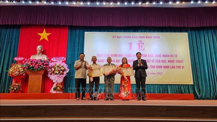 Trao tặng danh hiệu cao quý cho 3 nghệ nhân nhân dân. Ảnh: TTXVN phát