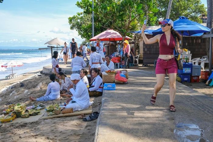  Du khách nước ngoài đi dạo trên bãi biển ở Kuta vào tháng 4. Ảnh: Nagi/EPA-EFE/Shutterstock. 