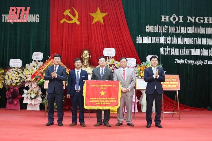 Thừa ủy quyền Chủ tịch UBND tỉnh, lãnh đạo huyện trao cờ thi đua cho Nhân dân và cán bộ xã Thiệu Trung có thành tích xuất sắc, dẫn đầu phong trào thi đua yêu nước năm 2022.