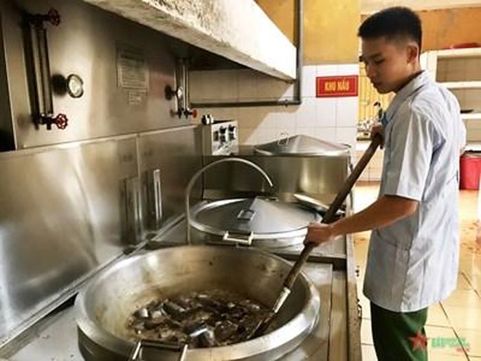 Binh nhất Mộng Văn Đức nấu ăn phục vụ bộ đội. Ảnh: HỮU TÂN