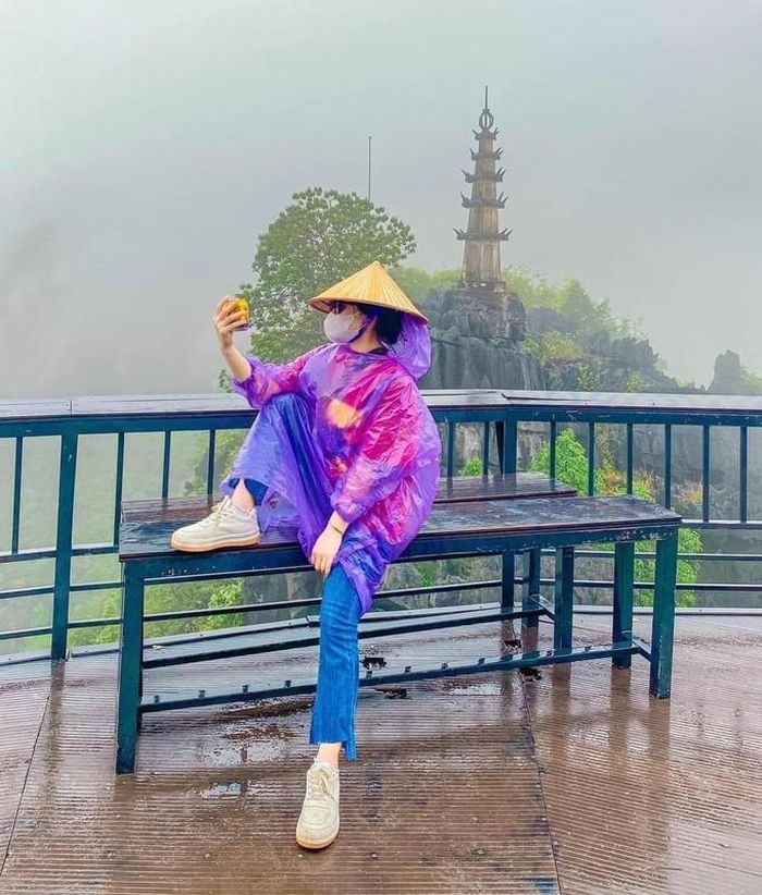 Để chuyến đi không uổng phí, đôi bạn trẻ vẫn mặc áo mưa và chụp ảnh tại các điểm check-in có tiếng.