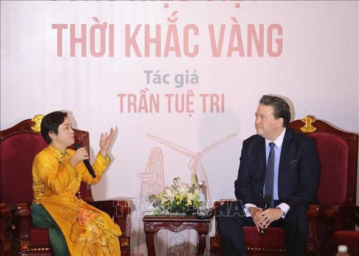 Tác giả Trần Tuệ Tri trao đổi cùng ngài Marc E. Knapper, Đại sứ Hoa Kỳ tại Việt Nam. Ảnh: Thanh Tùng/TTXVN