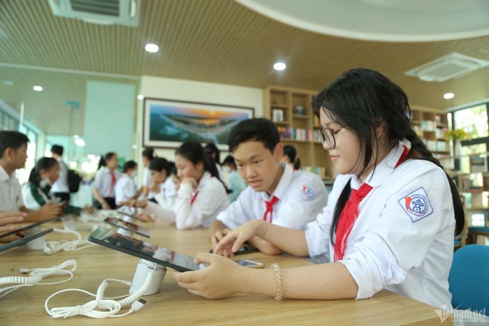  Em Bảo Ngọc (bìa phải) trải nghiệm đọc sách trên máy tính bảng.