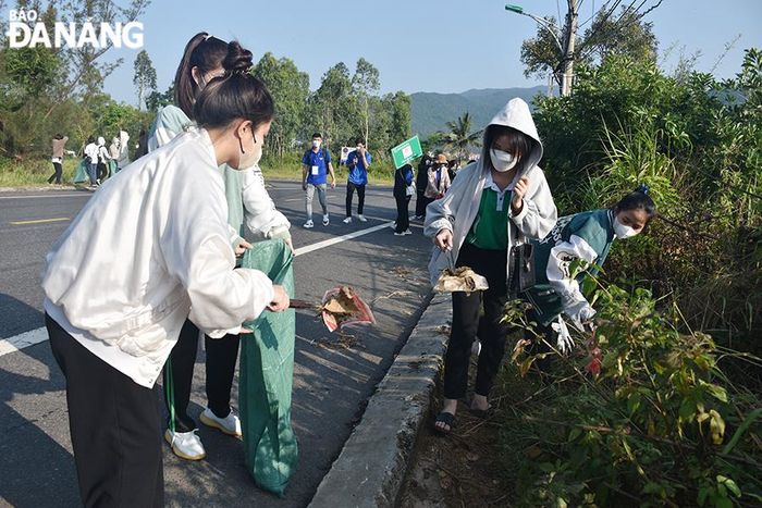 Các tình nguyện viên thu gom rác tại các khu vực ngã ba Lê Văn Lương - Hồ Xanh - chùa Linh Ứng... Ảnh: THU HÀ
