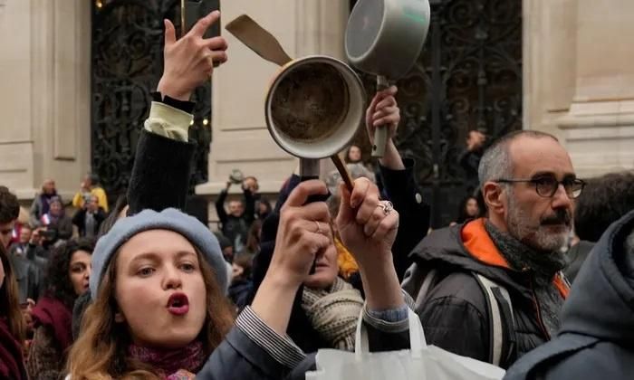 Người biểu tình tại Pháp mang xoong nồi ra gõ để phản đối ông Macron. Ảnh: AP/Guardian.