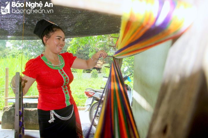 Đến nay, Phẩy Thái Minh, xã Tiên Kỳ là bản duy nhất của huyện Tân Kỳ đã được UBND tỉnh công nhận làng nghề dệt thổ cẩm vào năm 2015. Tại mỗi nếp nhà sàn trong bản đều có khung cửi, chị em miệt mài cần mẫn khéo léo để tạo ra nhiều sản phẩm thổ cẩm đẹp về mẫu mã, kiểu dáng, đảm bảo chất lượng nào là váy áo, khăn thêu, chăn, túi xách... Ảnh: Quang An