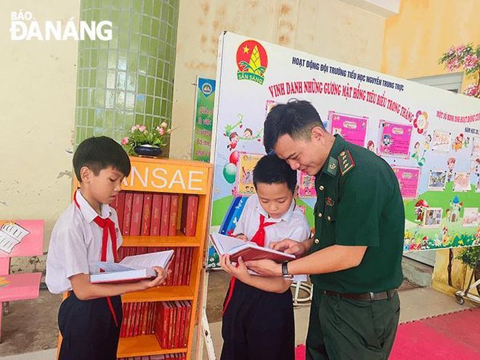 Thượng úy Nguyễn Xuân Tiến tặng sách cho học sinh Trường Tiểu học Nguyễn Trung Trực.