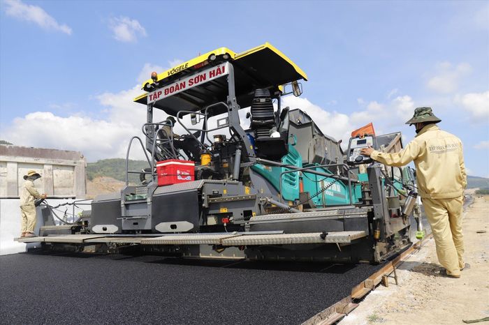 Công nhân điều khiển máy móc rải thảm nhựa trên cao tốc Nha Trang - Cam Lâm.
