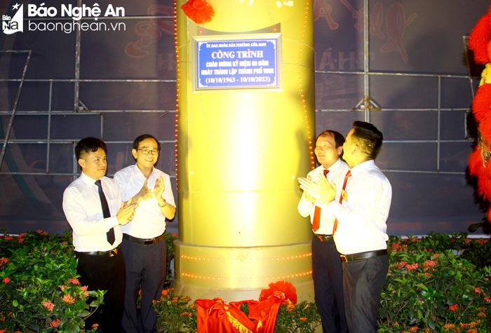 Các đại biểu thực hiện nghi thức gắn biển công trình chào mừng 60 năm thành lập TP. Vinh. Ảnh: Q.A