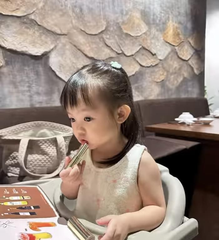 Suchin cầm thỏi son của mẹ tô lên môi, khuôn mặt liên tục có những biểu cảm dễ thương.