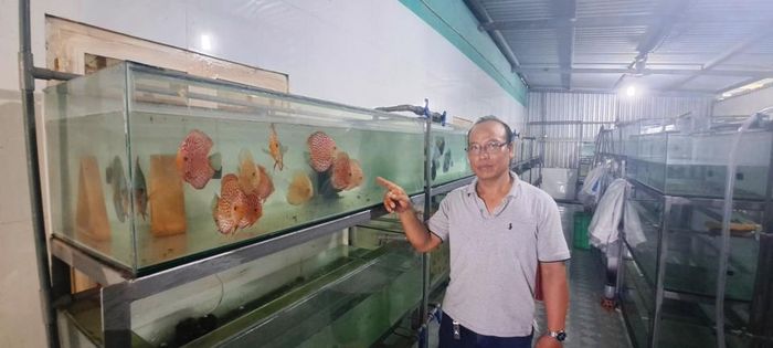 Anh Trương Trung Cường trong trại nuôi cá của gia đình. (ảnh: Tân Tiến).