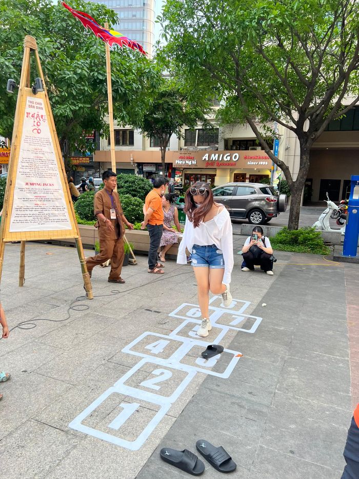 Nữ du khách trải nghiệm trò chơi nhảy lò cò.