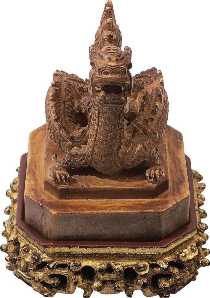  Mỗi cổ vật trong cuốn sách đều mang dấu tích của quá khứ. Có những cổ vật là biểu tượng cho quyền lực của hoàng gia, quan lại. Cũng có những cổ vật được lưu hành từ tầng lớp quý tộc cho đến bình dân xưa như: chạm bạc, đồ ngà, đồ sơn son thếp vàng, đồ gỗ chạm, pháp lam, đồ sứ… Trong ảnh là ấn rồng của vua Tự Đức được làm bằng chất liệu ngà voi châu Á. Ấn được làm vào tháng 6 năm Tự Đức thứ hai mươi sáu. Ấn có chiều cao 6,5 cm, dài 5,6 cm, rộng 5,6 cm, nặng 150 g, chạm hình rồng ngồi cuộn mình đầu đối thẳng hơi ngước lên, chân choãi, toát ra được vẻ oai nghiêm, uy dũng. 