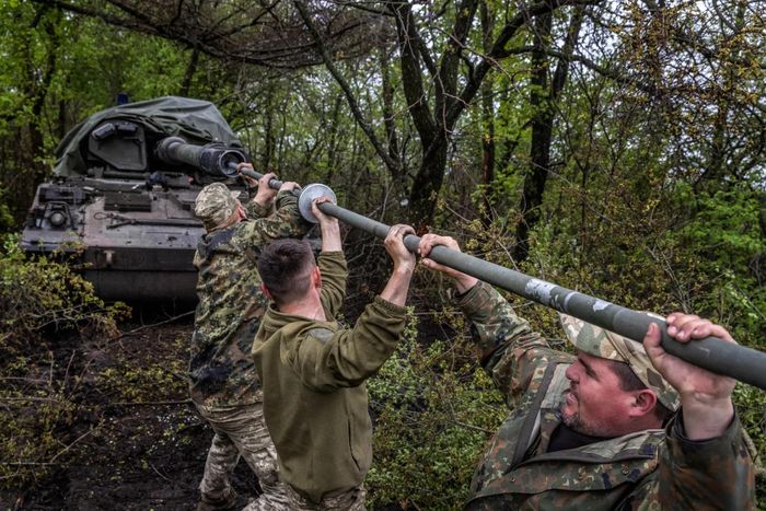 Các binh sĩ Ukraine vệ sinh pháo PzH. Ảnh: NYT