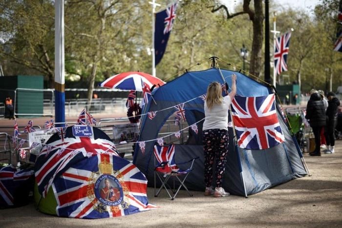 Họ cắm trại ngay bên ngoài cung điện Buckingham trước lễ đăng quang của Vua Charles và Hoàng hậu Camilla. Trong ảnh là một phụ nữ dựng lều trên đường The Mall, bên ngoài cung điện. (Ảnh: Reuters)