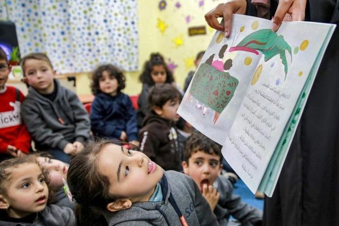 Trẻ em Jordan thích thú khi được nghe đọc truyện. Ảnh: AFP