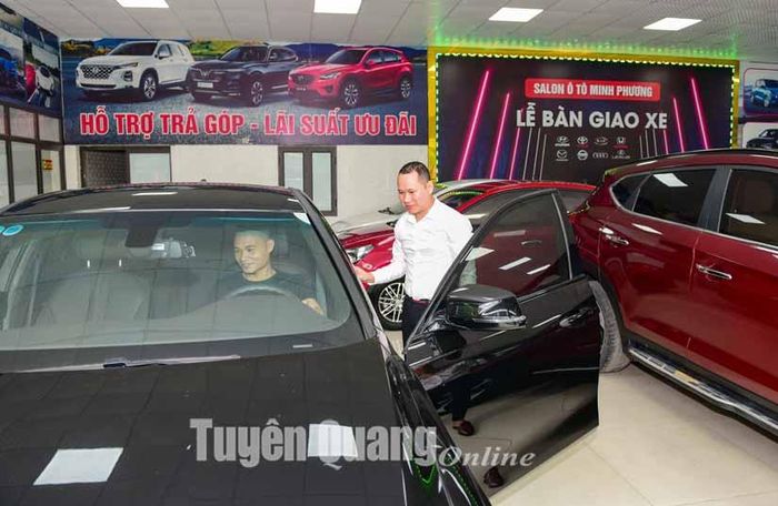Nhân viên Salon ô tô Minh Phương giới thiệu cho khách hàng các sản phẩm ô tô tại cửa hàng.