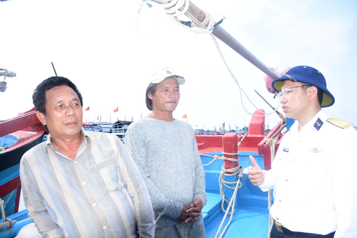 Cán bộ Trung tâm Dịch vụ hậu cần-kỹ thuật đảo Trường Sa tuyên truyền ngư dân khi neo đậu tại âu tàu. 