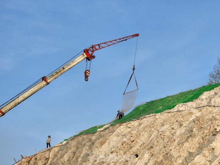 Công nhân đang thi công taluy chống sạt lở trên đỉnh núi.