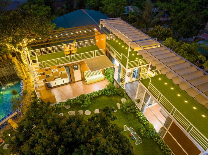 Sân vườn sắp đặt tiểu cảnh, xích đu, cầu trượt cho trẻ và bàn trà cho người lớn.