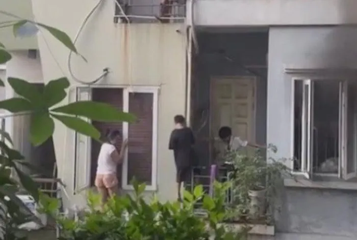 Bé trai cùng người thân leo ban công thoát nạn.
