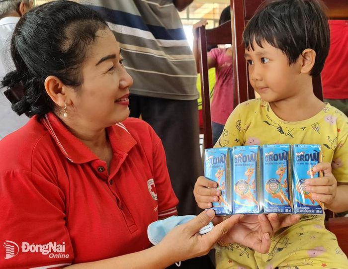 Bà Đỗ Thị Phước Thiện, Chủ tịch Hội Chữ thập đỏ tỉnh tặng quà cho một trẻ em tại xã Tà Lài, H.Tân Phú sáng 18-5. Ảnh: Hoàng Nhung