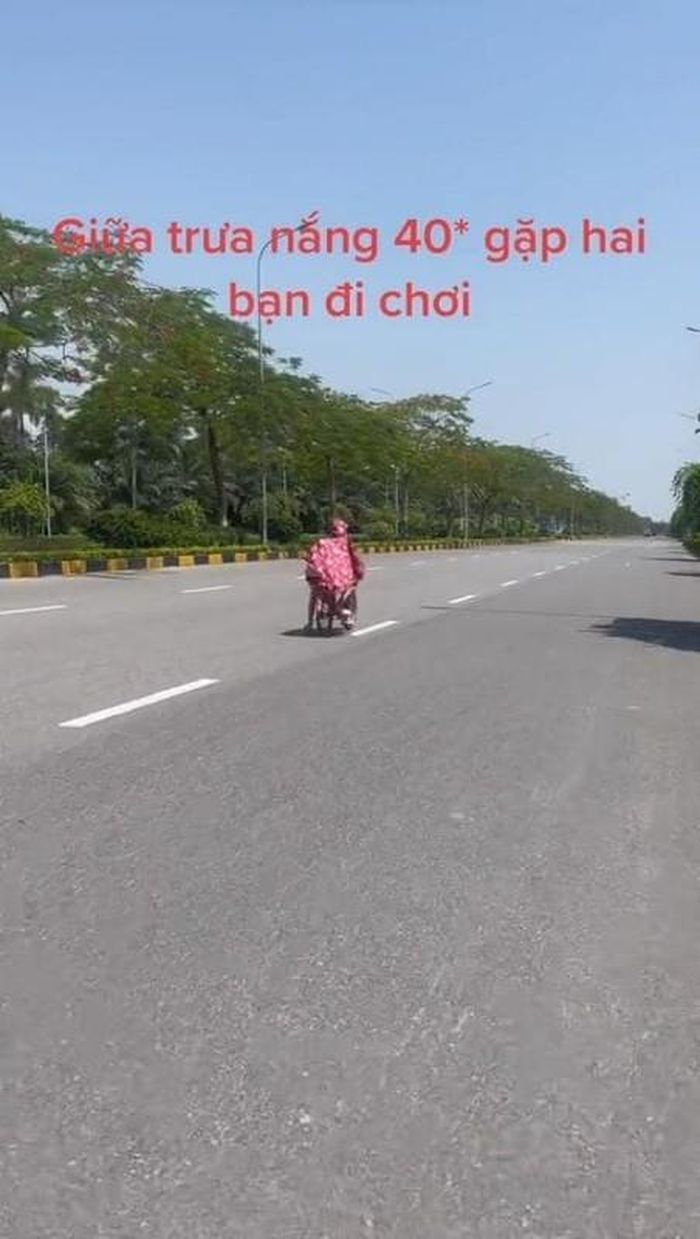 Theo clip ghi lại, thời điểm Hà Nội nắng nóng 40 độ, đường phố gần như không có ai đi lại thì xuất hiện hai em nhỏ đi xe đạp màu hồng, trùm áo mưa hồng và thong thả đạp xe giữa lòng đường.