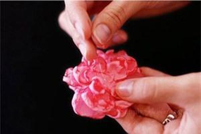Cuối cùng, chồng các lớp hoa lại rồi dùng chỉ khâu cố định chúng lại với nhau.