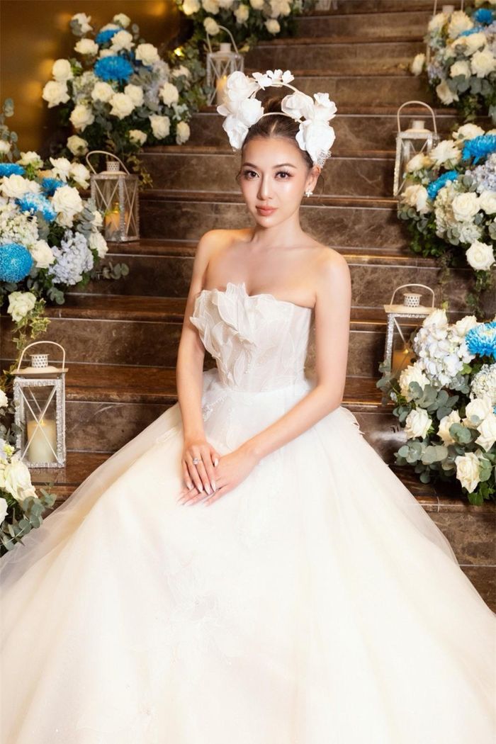 Cô diện mẫu váy cưới trắng cách điệu được thiết kế kỳ công với phom dáng ôm, xẻ ngực và tôn đường cong cơ thể. Tang phục với họa tiết cổ điển, đính ren và đá nhẹ tạo hiệu ứng thẩm mỹ được đánh giá là phù hợp vơíSherri Phan.