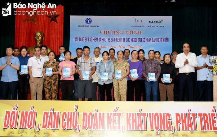 Lãnh đạo BHXH tỉnh và Quỹ Vì Tầm Vóc Việt - Ngân hàng Thương mại cổ phần Bắc Á trao tặng thẻ Bảo hiểm y tế cho người dân có hoàn cảnh khó khăn ở phường Vinh Tân (TP. Vinh). Ảnh: Công Kiên