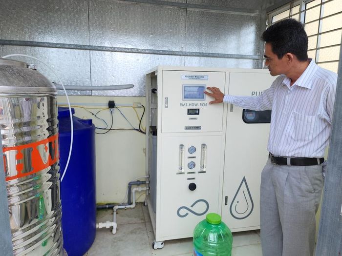 Bác sỹ Nha Văn Ửng đang chỉ cho phóng viên xem thiết bị lọc nước trị giá hàng trăm triệu đồng của Trạm y tế xã Điền Hải không thể hoạt động (tháng 9/2022)