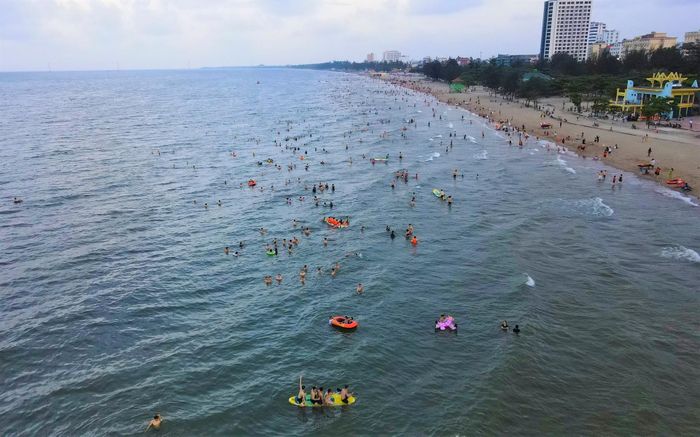 Khu du lịch biển với bãi cát phẳng, mịn, trải dài khoảng 10 km càng xứng tầm là một trong những bãi tắm đẹp nhất miền Trung. Trong ảnh, cảnh hàng nghìn du khách tắm mát trải dài suốt chiều dài bãi biển.