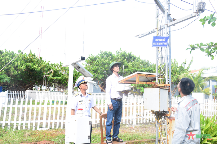 Kỹ thuật viên quan trắc (người đứng giữa) đo và ghi chép số liệu tại đảo Trường Sa lớn.