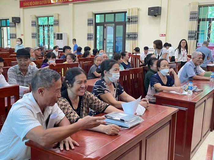 Các hộ gia đình ở xã Văn Bình ngồi chờ đến lượt gọi nhận tiền bồi thường GPMB dự án đường Vành đai 4.