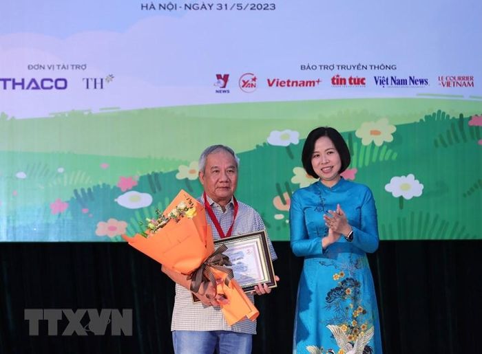 Tổng Giám đốc TTXVN Vũ Việt Trang trao Giải thưởng lớn “Hiệp sỹ Dế mèn” và chứng nhận cho nhà văn Trần Đức Tiến với truyện dài “A lô! Cậu đấy à.” (Ảnh: Hoàng Hiếu/TTXVN)