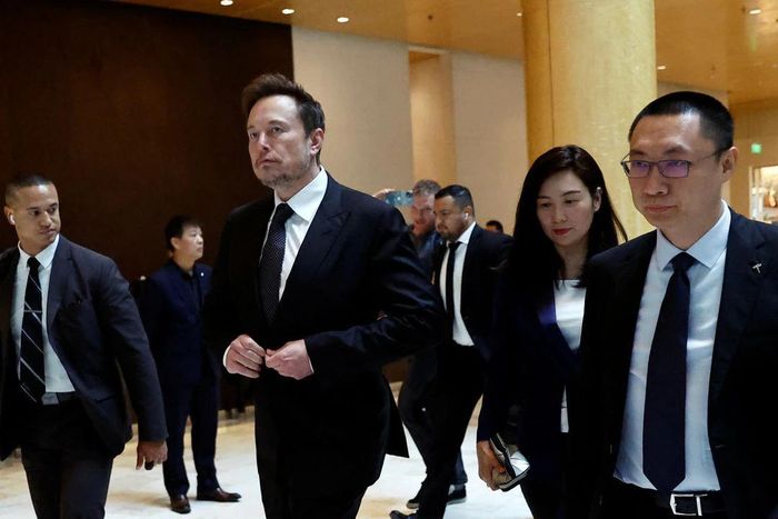 Elon Musk rời khách sạn tại Bắc Kinh ngày 31/5 cùng với hai phó chủ tịch cấp cao của Tesla Trung Quốc. (Ảnh: Reuters)