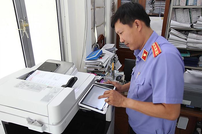 Kiểm sát viên Phòng 9 scan hồ sơ vụ án dân sự để lưu trữ điện tử.