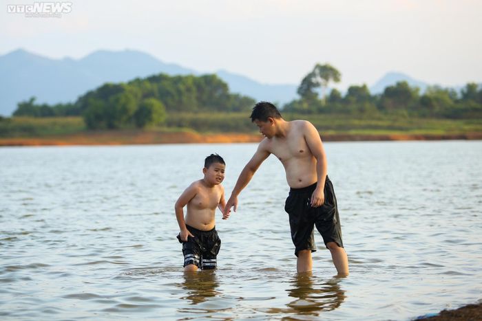 Nhiều trẻ nhỏ thích thú bơi lội dưới dòng nước mát nhiều giờ không chịu lên bờ.