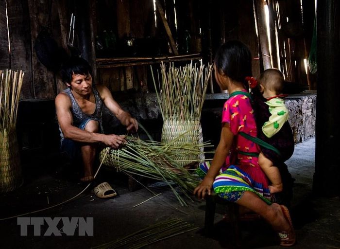  Người dân Mông đan quẩy tấu. (Ảnh: Nam Thái/TTXVN) 