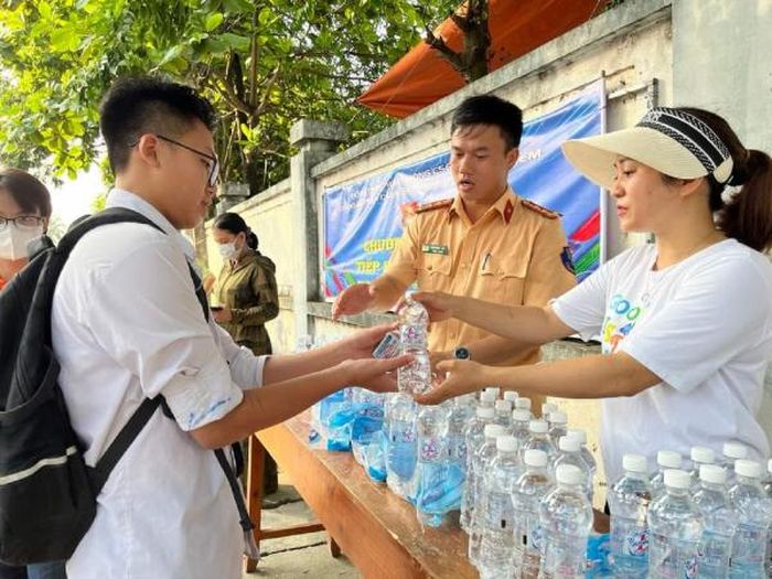 Tình nguyện viên Công an phát nước uống miễn phí tặng các thí sinh.