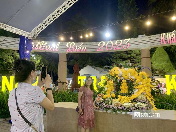 Người dân, du khách chụp hình lưu niệm với các tác phẩm nghệ được trang trí bằng hoa, quả, củ...