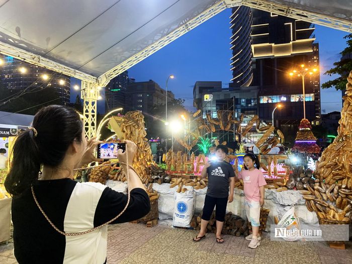 Du khách nước ngoài thích thú chụp hình tại triển lãm "Bánh mì Nha Trang xưa và nay". Tại đây có tháp bánh mì cao 3m, dài 6m.