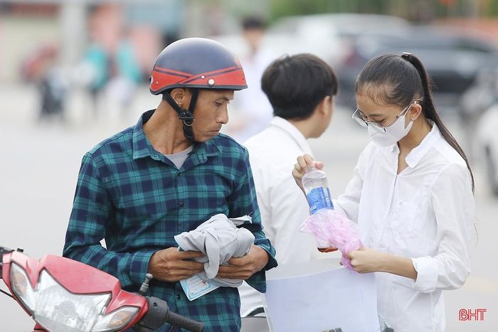 Nhiều phụ huynh chở con đến trường bằng xe máy và cùng con kiểm tra kĩ các giấy tờ thi, vật dụng cần thiết. Ảnh tại điểm thi Trường THPT Nghèn (Can Lộc).