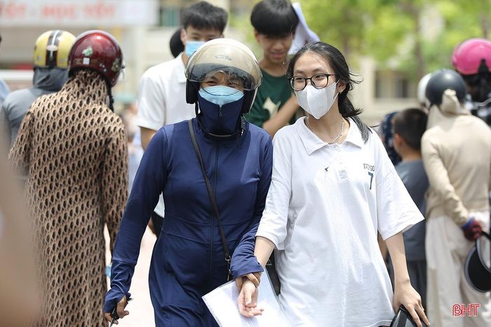 Cánh cửa trường thi mở ra, các bậc phụ huynh ùa vào động viên, hỏi thăm tình hình... Ảnh tại điểm thi Trường THPT Nghèn (Can Lộc).
