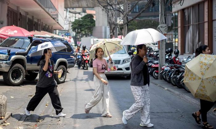 Người dân vội vã băng qua đường giữa cái nóng hơn 40 độ C tại Bangkok,Thái Lan. Ảnh: Guardian